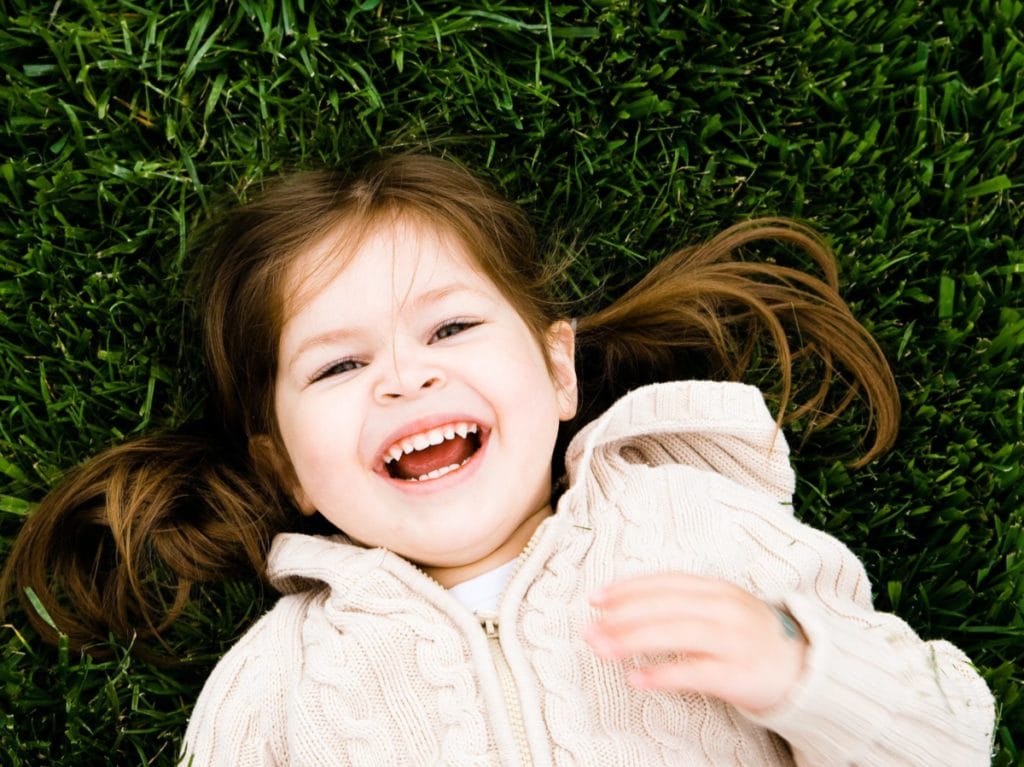 Girl lying in grass PACT